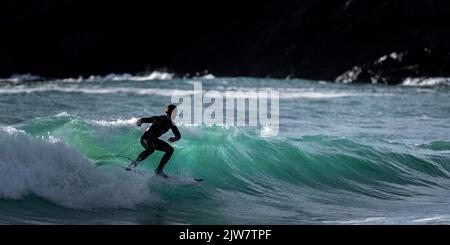 Les surfeurs ont capturé à cheval les meilleures vagues de Cornwall sur le récif de Porthleven. De magnifiques vagues turquoise s'élèvent au large du récif. Banque D'Images