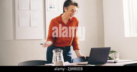 Bonne femme d'affaires en train de lui faire part de son idée lors d'une réunion en ligne. Designer souriant discutant de son plan pendant un appel vidéo. Femme d'affaires mature Banque D'Images