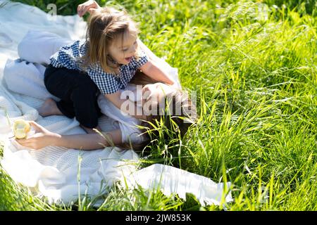 Frère et sœur se réjouîssent de rire, allongé sur l'herbe verte. Le soleil brille, les enfants sont heureux insouciant. Le concept d'une vie de famille heureuse et de liaison. Copier l'espace. Banque D'Images