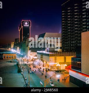 Atlantic City, 1980s personnes se promènent sur la promenade, Atlantis Hotel casino bâtiment, nuit, New Jersey State, NJ, USA, Banque D'Images