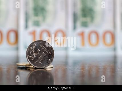 1 gros plan de la monnaie du rouble russe sur fond flou des billets en dollars Banque D'Images