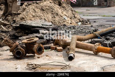 Vieux tuyaux d'eau rouillés en cours de rénovation sur la rue de la ville Banque D'Images