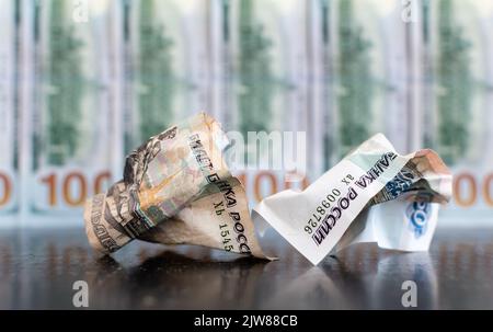 Gros plan sur des billets de banque en dollars froissés de roubles russes sur fond flou Banque D'Images