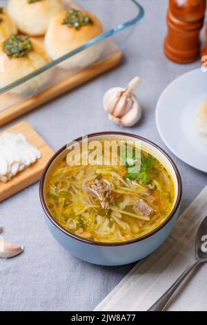 Shchi avec pampuckki (petits pains) et saindoux. Soupe de chou, pommes de terre et viande. Cuisine russe et ukrainienne traditionnelle. Gros plan. Banque D'Images