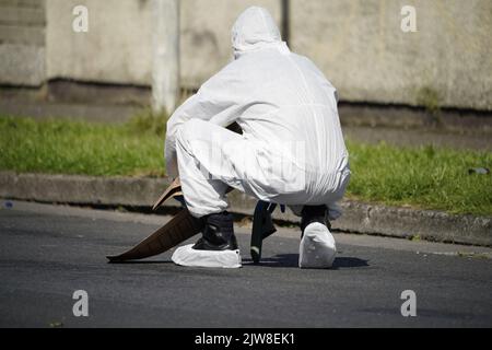 Des policiers ont retiré une chaussure de la scène dans le domaine de Rossfield à Tallaght, Dublin, après la mort d'une femme de 18 ans et de son frère et sœur, jumeaux âgés de huit ans, à la suite d'un incident violent dans une maison. L'unité de soutien armé de Garda a utilisé des dispositifs moins létaux pour arrêter un homme au début de 20s sur les lieux. Date de la photo: Dimanche 4 septembre 2022. Banque D'Images