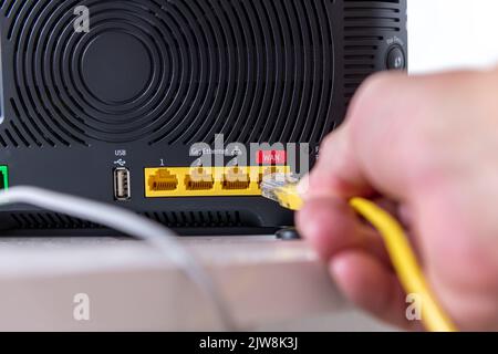 Personne connectant un périphérique à un routeur Internet. Banque D'Images