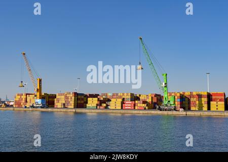 Anvers, Belgique - août 2022 : grues et conteneurs d'expédition stockés sur le côté du port commercial de la ville Banque D'Images