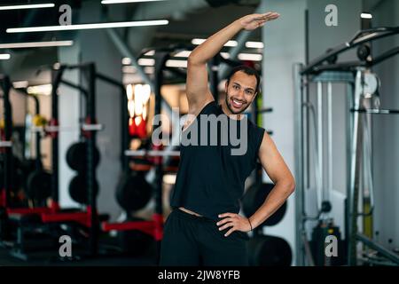 Athletic Young African American Man s'étirant sur les côtés pendant l'entraînement à la salle de gym Banque D'Images