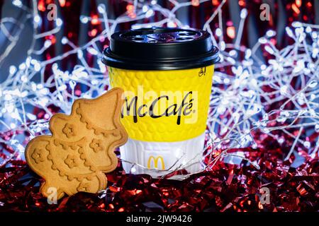 Tasse de Noël de biscuits McDonald's et gingembre sous forme d'arbre de Noël sur fond d'une guirlande de guirlande rouge. Kiev, Ukraine Banque D'Images