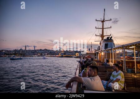 Istanbul, Turquie. 03rd septembre 2022. Les gens vus assis sur la terrasse des lignes de la ville ferry au coucher du soleil à Istanbul et le pont de Galata en arrière-plan avec les nuages ont créé une vue magnifique. (Photo par Onur Dogman/SOPA Images/Sipa USA) crédit: SIPA USA/Alay Live News Banque D'Images