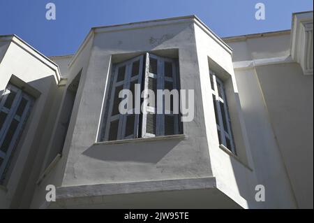 Façade ancienne avec volets en bois gris sur un mur blanchi à la chaux. Banque D'Images