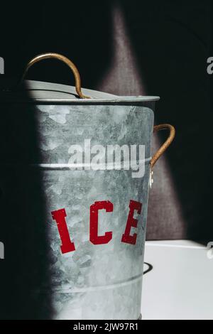 Seau à glace en métal avec panneau rouge partiellement éclairé Banque D'Images