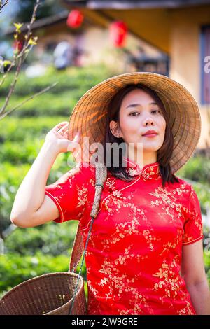 Portrait de femme asiatique détendez-vous dans la robe longue de style chinois ou vietnam accessoires contemporains heureux sur place matin Banque D'Images