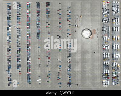 Vue aérienne de haut en bas de l'importation et de l'exportation de voitures de stockage dans le port. Véhicules neufs de l'industrie automobile, parking en stationnement prêt pour l'expédition Banque D'Images
