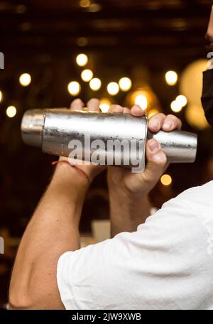 Barman préparant un cocktail. Préparation de cocktails dans un environnement nocturne. Il peut s'agir d'un hôtel, d'un restaurant ou d'une discothèque. Vie nocturne Banque D'Images