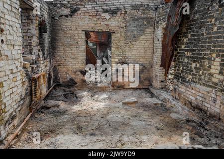 Maison en ruines. Ruines d'un bâtiment résidentiel. Murs de briques. La guerre en Ukraine. Une maison détruite par une fusée et un incendie. Une pile de briques. Une vie brûlée. Banque D'Images