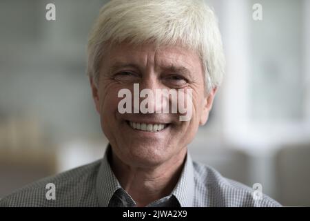Heureux beau homme caucasien âgé aux cheveux gris posant à l'intérieur Banque D'Images