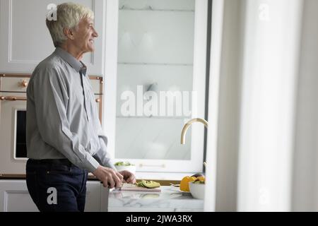 Joyeux homme de rêve en appréciant la cuisine dans la cuisine moderne maison Banque D'Images