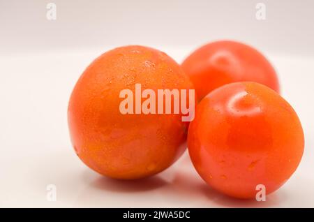 gros plan détaillé de trois tomates mûres étincelant Banque D'Images