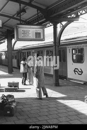 Image des voyageurs en train sur la première plate-forme de la gare de N.S. Nijmegen à Nimègue, avec sur la voie 1B un train diesel-électrique a établi le 3 (plan U) de la N.S. Comme un train lent à Roermond. Banque D'Images