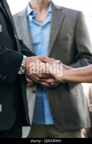 Mariée et marié tenant les mains pendant le mariage à l'extérieur. L'amour est dans l'air Banque D'Images