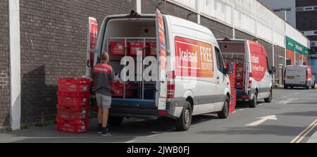 Plymouth, Devon, Angleterre, Royaume-Uni. 2022. Une épicerie et une camionnette de livraison de nourriture sont chargées avec des boîtes en plastique rouge par un chauffeur de livraison. Banque D'Images