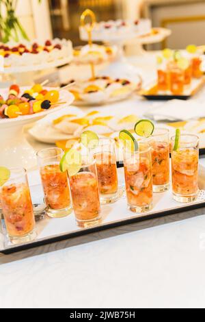 Sélection d'un plateau avec des verres et un cocktail de crevettes au buffet de nourriture Banque D'Images