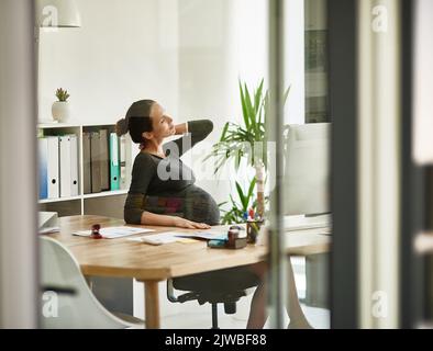 Laisse ne peut pas venir assez vite. Une femme d'affaires enceinte dans l'inconfort dans son bureau. Banque D'Images