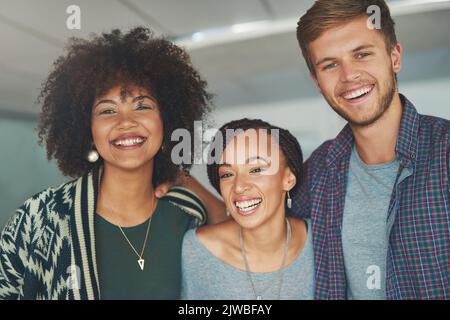 C'est une équipe de jeunes créatifs. Portrait d'un groupe de jeunes collègues heureux et prospères dans un bureau moderne. Banque D'Images