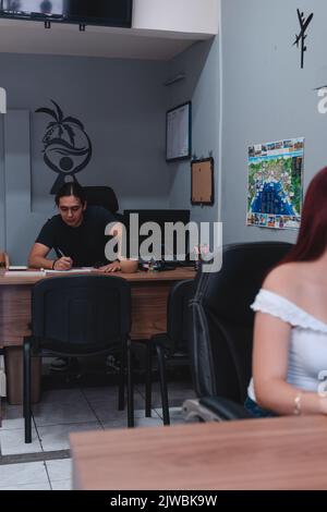 Agence de voyages avec deux agents de vente travaillant dans le bureau. Deux employés dans leur bureau avec deux bureaux. Photo de haute qualité Banque D'Images