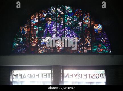 Image du vitrail semi-rond au-dessus de l'entrée du bureau de poste principal (Neude 11) à Utrecht. La fenêtre a été conçue par le professeur R.N. Roland Holst et a été dévoilé en 1931. Il s'agit d'une représentation de la Vierge hollandaise, reposant dans le jardin des provinces, entourée d'un vol de pigeons porteurs et d'armes provinciales. Banque D'Images