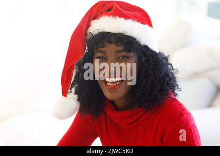 Portrait d'une femme afro-américaine portant un chapeau de père noël Banque D'Images