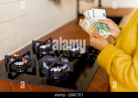 Compter les billets en euros près du poêle à gaz en feu Banque D'Images