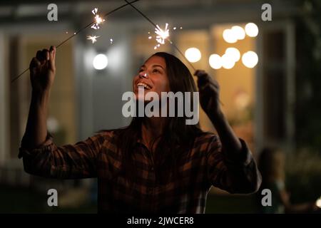 Femme caucasienne tenant deux sparklers Banque D'Images