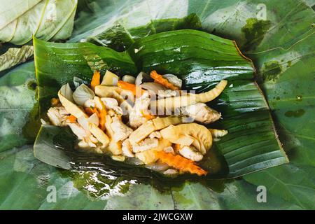 Pousses de bambou sautées au porc servies sur une feuille de banane, un plat traditionnel khmer Banque D'Images