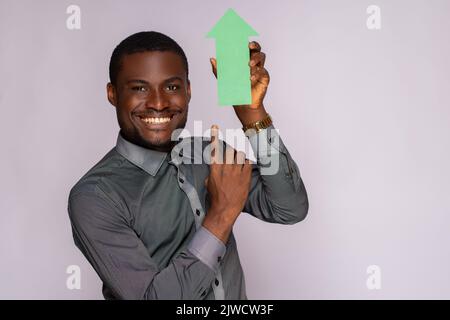 beau homme africain tenant une flèche pointant vers le haut Banque D'Images