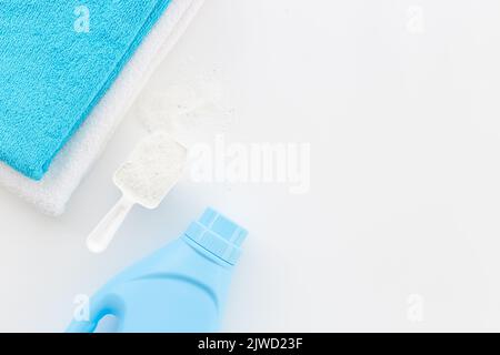 Poudre blanche à laver avec serviettes et une bouteille de conditionneur de linge Banque D'Images
