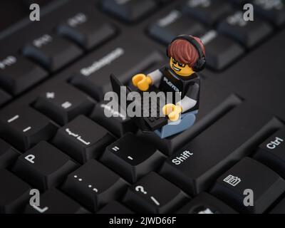Tambov, Fédération de Russie - 25 août 2022 Un jeu vidéo Lego Guy minifigure assis sur un clavier d'ordinateur et jouant sur un ordinateur portable. Banque D'Images
