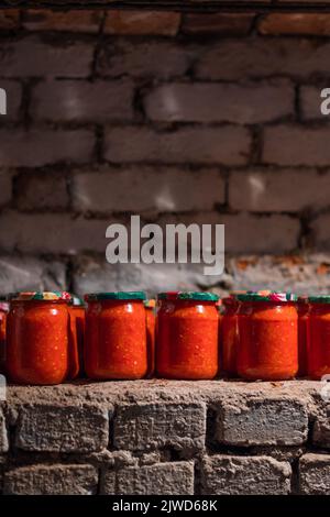 Nourriture en conserve sur une étagère en brique dans un abri à la bombe. Alimentation en pots de verre Banque D'Images