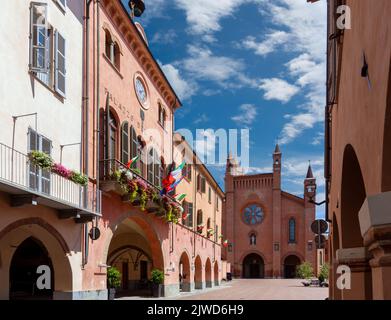 Alba, Langhe, Piémont, Italie - 16 août 2022: L'Hôtel de ville avec balcons fleuris et arcades médiévales dans la via Cavour, en arrière-plan Cathédrale Banque D'Images