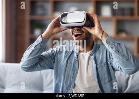 Jeux vidéo. Portrait d'un homme noir émerveillé portant des lunettes VR à la maison Banque D'Images