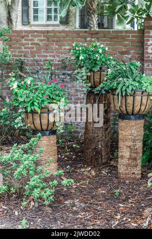 Un ensemble de trois plantes surélevées d'extérieur dans des sacs de panier de semoir avec une variété de plantes pour un look unique paysagé Banque D'Images