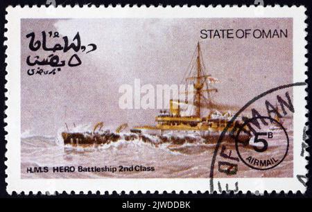 OMAN - VERS 1977: Un timbre imprimé dans l'État d'Oman montre HMS Hero, était le deuxième et dernier cuirassé de la classe Conquérant était un ironclad qui a servi dans Banque D'Images