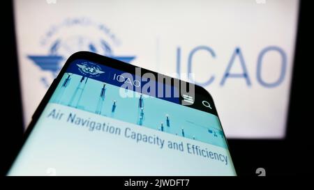 Smartphone avec page Web de l'Organisation de l'aviation civile internationale (OACI) à l'écran devant le logo. Faites la mise au point dans le coin supérieur gauche de l'écran du téléphone. Banque D'Images