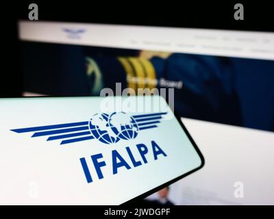 Smartphone avec logo de l'association pilote internationale IFALPA à l'écran devant le site. Mise au point à gauche de l'écran du téléphone. Banque D'Images