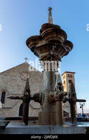 Rhodes, Grèce - 24 août 2022 : vue panoramique colorée sur le port de Mandraki au coucher du soleil. Cathédrale de Podos, église de l'Annonciation et fontaine, Rhodes Grèce Banque D'Images