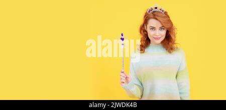 femme souriante à tête rouge dans la couronne de reine avec baguette magique, wish. Femme isolée visage portrait, bannière avec espace de copie. Banque D'Images