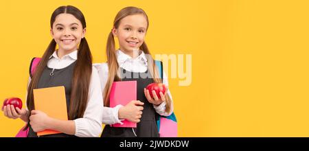 Filles d'école amis. Développer les connaissances sur une alimentation saine. Les enfants tiennent des livres et des pommes. Bannière de l'élève de la jeune fille. École enfant élève Banque D'Images