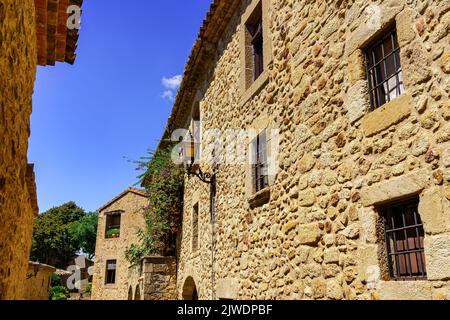Façades de vieilles maisons en pierre avec fenêtres bardées et portes en bois, Pals, Gérone. Banque D'Images