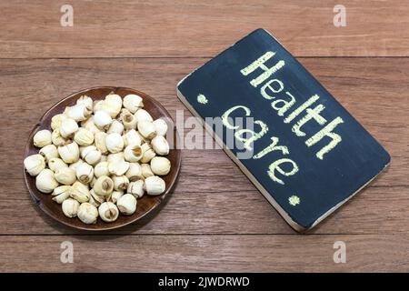 Dried lotus seeds on a wooden background. Stock Photo